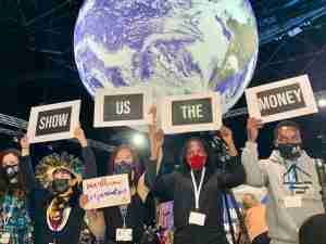Activistas muestran carteles que dicen MUESTAME EL DINERO en la COP26, Noviembre 2021.